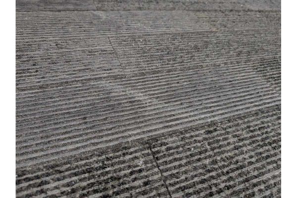 Close-up of Ash Grey Granite Cladding highlighting fine grooved lines and a lightly speckled finish.***
