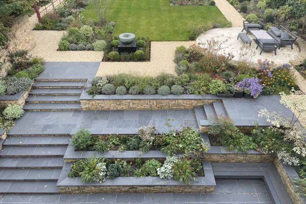 Tiered landscape design featuring Brazilian Black Slate Bullnose Steps and mixed planting.***Designed by Clare McMillan Garden Design | Built by Landscaping Solutions Ltd