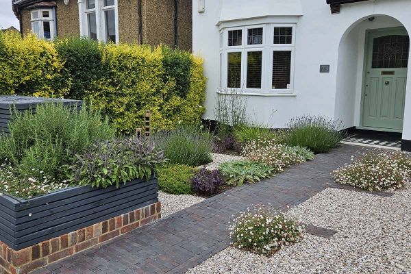 Front of house shot showing path of ancona clay pavers with insets to create flowerbeds, surrounded by pebbles.***Catriona Rowbotham Garden Design, www.crowbothamgardendesign.co.uk