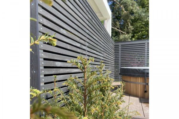 Dark Ash composite battens used for long, tall screen to edged boarded outdoor area with yew. Designed by Thouvenin Landscapes.***Image also displays Millboard Burnt Cedar Fascia | Thouvenin Landscapes Ltd, www.thouveninlandscapes.com
