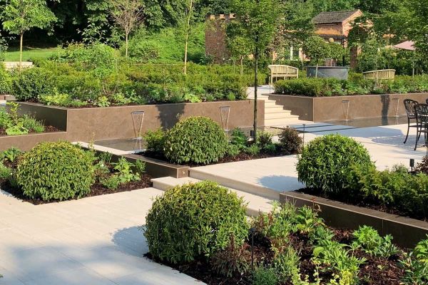 Multi-level garden with dining area and raised garden bed, large clad built-in planters and Faro Porcelain 36mm Bullnose Steps.***Botanica Garden Design, www.botanicagardendesign.com