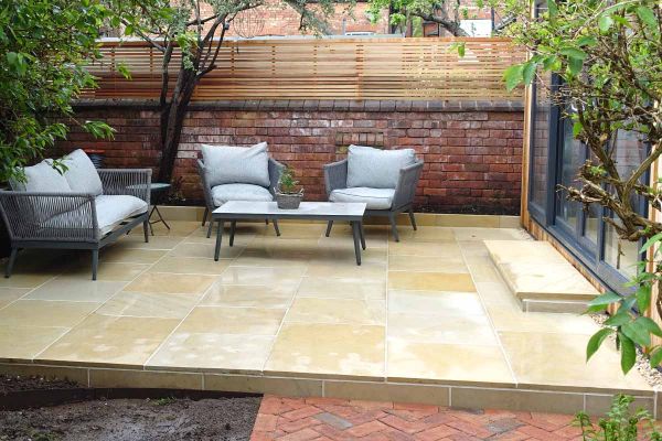 A back garden with Harvest Edging Stones, matching paving, and bullnose steps in warm pastel colours, leading to an outhouse.***Pev’s Paving & Landscaping, www.facebook.com/pevspaving
