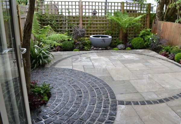 Neat design showing a full circle paved with Natural Black Granite Setts, and one outline of a circle.***Living Spaces,  www.lsgardendesign.com
