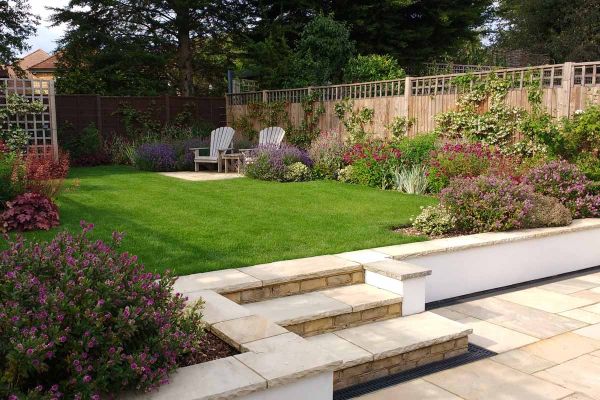 Rendered white wall leading to raised lawn capped by mint indian sandstone coping stones with matching paving and steps.***Rhoda Maw Garden Design, www.rhodamaw.com