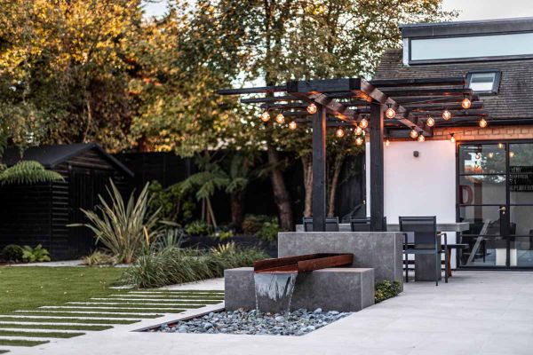 Steel corten trough flows water into pebbled area with raised walls clad with vulcano ceniza designclad in unique feature.***Gardens of the Future, www.gardensofthefuture.co.uk
