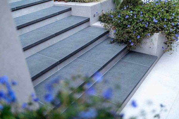 Steel Grey porcelain steps with 20mm downstand, next to DesignClad-faced stepped planters. Design by Gardens of the Future. ***Gardens Of The Future, www.gardensofthefuture.co.uk
