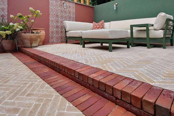Limestone pavers in herringbone style and seville clay pavers used as border bricks and step up to lounge area.***Katerina Kantalis Garden Design
