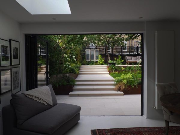 Interior space featuring porcelain patio, sliding doors, and Faro Porcelain 36mm Bullnose Steps leading to seating area.***36mm Bullnose | Taryn Ferris Gardens & Nordland Landscapes
