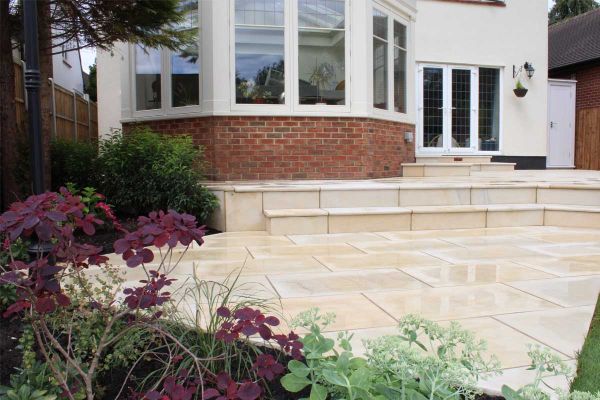 Harvest smooth sandstone bullnose steps rise to patio outside folding doors and deep bay window. Built by Essex Garden Designs.***Essex Garden Designs, www.essexgardendesigns.co.uk

