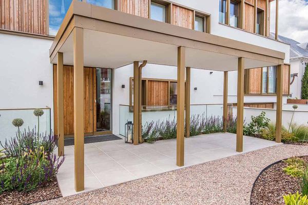 Cement porcelain patio in front of Scandinavian-style house with wooden windows and planting such as salvias and alliums.***Windsor & Harris Landscapes,  www.whscapes.co.uk (photo credit Matt Woods Photography)