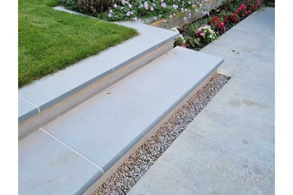 Contemporary Grey sandstone bullnose step rises past planted bed on 2 levels to coping edge of lawn from matching paving below.***Landscape Artisan, www.landscapeartisan.co.uk
