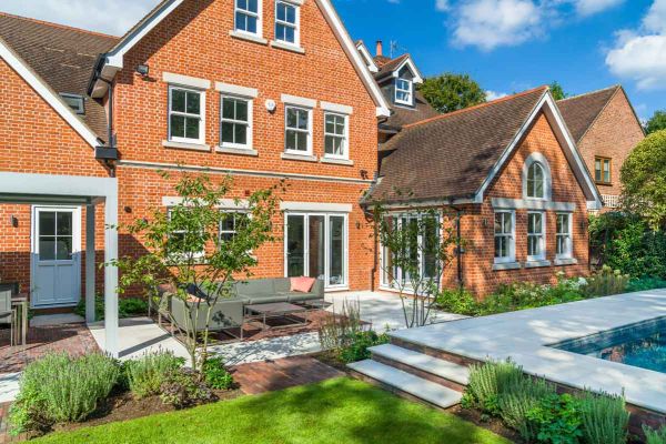 3 Dove Grey Sawn sandstone bullnose steps rise to swimming pool surround in matching paving, by patio with garden lounge set.***Graduate Landscapes,  www.graduatelandscapes.co.uk