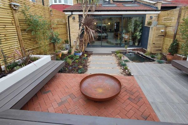 Delta Light Multi driveway pavers laid herringbone fashion in back-garden seating area with raised beds, bench and round firebowl.***Image also displaying Nuage Porcelain Paving | Floral & Hardy Garden Design, www.floralandhardy.co.uk