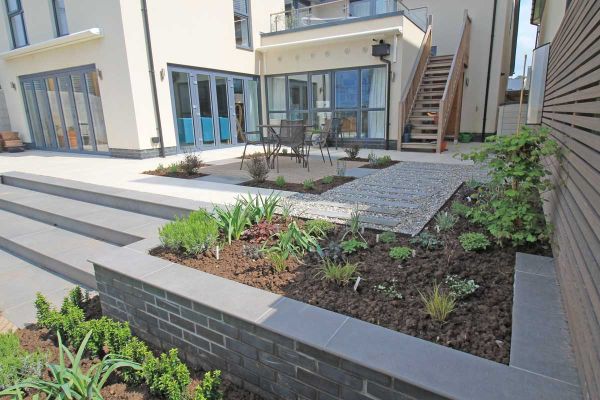 3 wide steps ascend to patio in pale paving next to garden walls capped with Steel Grey porcelain 20mm bullnose coping stones. ***Outerspace Creative Landscaping, www.outerspacegardens.co.uk
