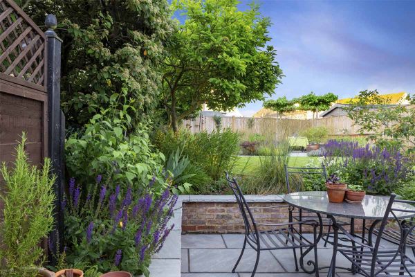 Kandla Grey Indian sandstone coping stones with rock-faced profile top brick wall surrounding patio in matching paving.***Designed by Bob Richmond Watson Landscape & Garden Design,  www.bobrichmondwatson.com  |  Built by Acacia Gardens,  www.acacia-garden