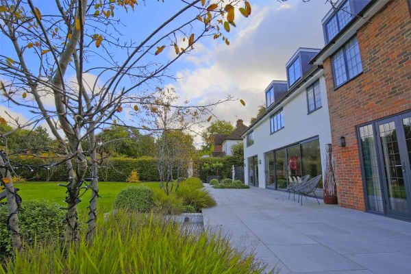 Seen from one end, Urban Grey Porcelain patio, by Karen McClure Garden Design, stretches across width of house, lawn on left.***Design by Karen McClure Garden Design,  www.karenmcclure.co.uk | Built by Langdale Landscapes,  www.langdalelandscapes.co.uk