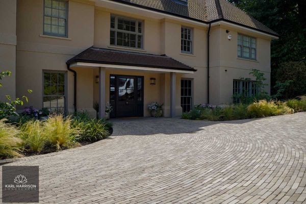 Wide drive of Gromo Antica brick pavers laid in curved pattern in front of house in deep shadow. Design by Karl Harrison.***Karl Harrison Landscapes, www.karlharrison.design
