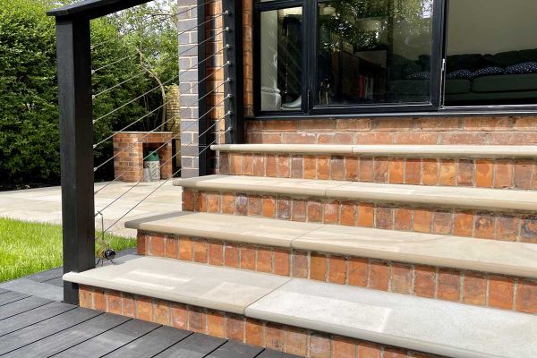 4 brick steps with Light Buff sawn sandstone treads rise to modern double doors from decking area in back garden.***Bark, Brick & Block, www.barkbrickblock.com