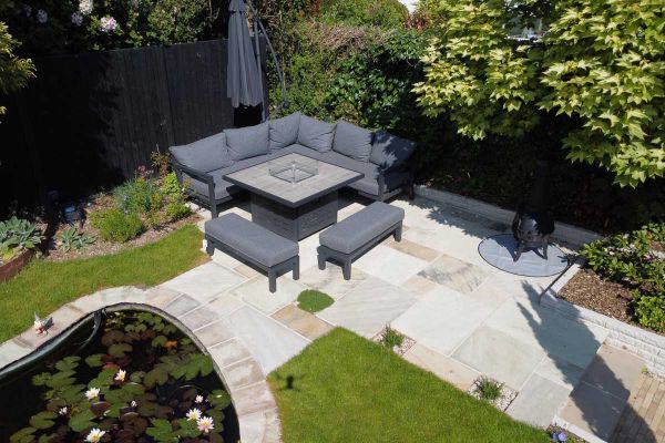 Garden  patio of Mint Indian sandstone paving with curved pond, borders with mature trees, and outdoor furniture.***Montrose Landscape Gardens, www.montrose-landscapes.com

