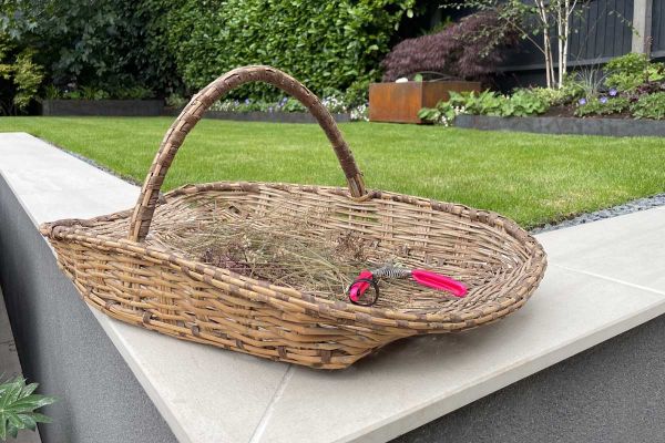 Flower basket sits on corner of Faro porcelain smooth coping on level with lawn, atop retaining wall. Design by Martyn Wilson.***Designed by Wilson Associates Garden Design, www.wilsongardendesign.co.uk | Built by JG Landscaping, www.jglandscapinguk.com