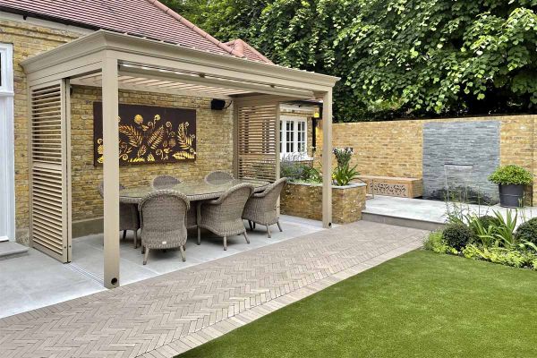 An apron of Stone Grey clay pavers edges Jura Grey patio, with rattan furniture and wooden pergola in colour to match brick paving.***Tom Howard Garden Design & Landscaping,  www.tomhowardgardens.co.uk
