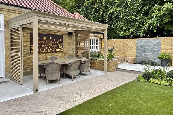 An apron of Stone Grey clay pavers edges Jura Grey patio, with rattan furniture and wooden pergola in colour to match brick paving.***Tom Howard Garden Design & Landscaping,  www.tomhowardgardens.co.uk