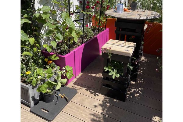 Kneeler and secateurs on Warm Teak Decking composite, with veg-planted troughs and table and stool. Design by the Cloud Gardener.***Designed by Jason Williams, www.cloudgardeneruk.co.uk | Built by Big Fish Landscapes, www.bigfishlandscapes.co.uk