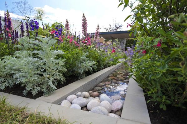 View down long rill filled with pebbles, with Heath smooth sandstone pencil round coping stone edges, plants on both sides.***Designed by Will Williams Garden Design,  www.willwilliamsgardendesign.com,  Built by Burnham Landscaping,  www.burnhamlandscapin