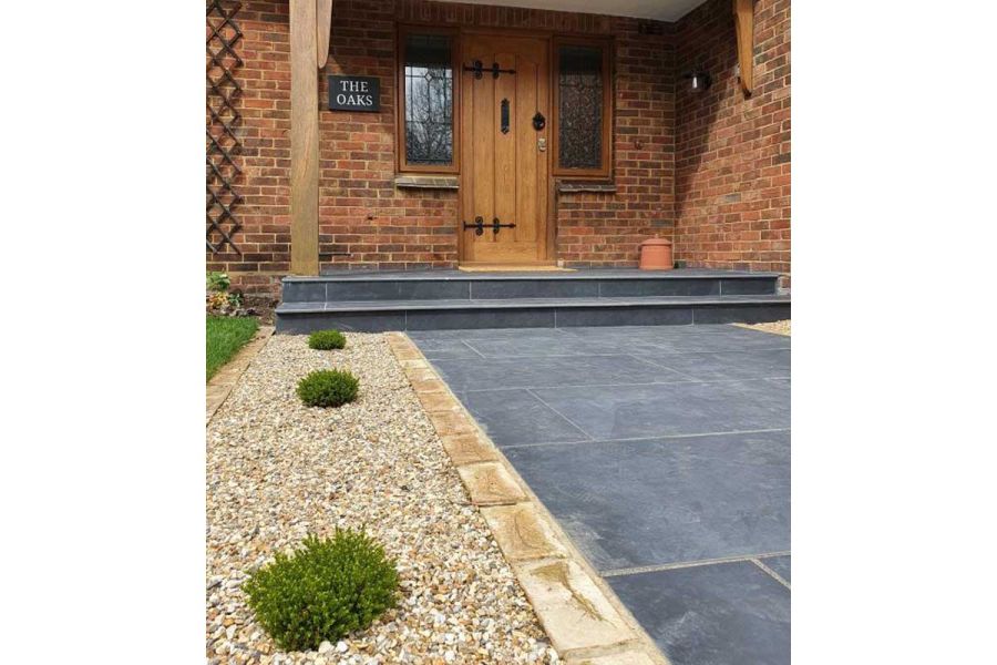 2 wide bullnose Charcoal porcelain paving steps up to house porch from matching front path edged with gravel bed and setts.