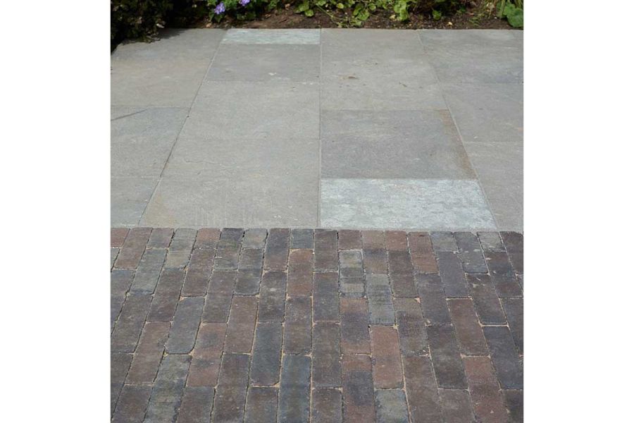 Ancona brick paved area laid flush with natural stone paving. Design by Bramley Apple. Built by Waterfeatures Ltd.