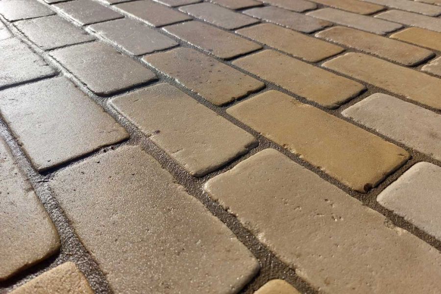 Oblique view across surface of Tumbled Mint sandstone setts with dark mortar joints. Design by Andy Lewis.