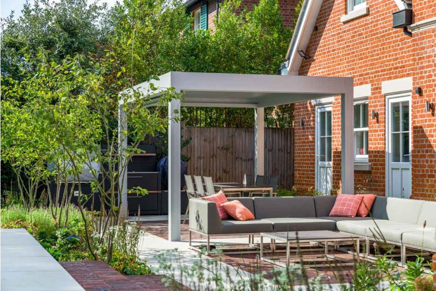 Dove Grey sawn sandstone patio designed by Graduate Landscapes. Antique Red clay pavers demarcate seating and outdoor dining areas.