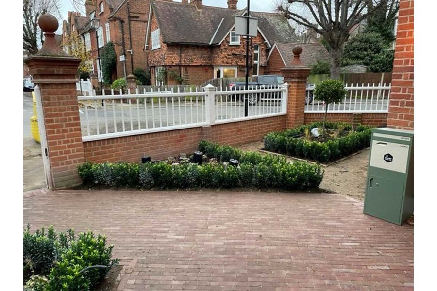 Front garden of corner house. 3 beds planted with hedging. Drive laid at angle with Roma Clay Pavers. Built by AS Landscapes.