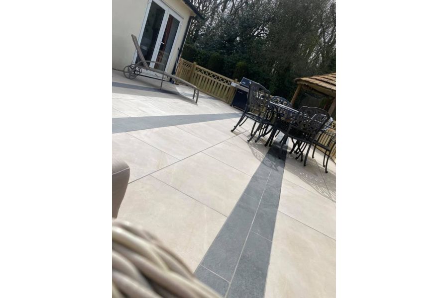 Large area of Ash Beige porcelain paving designed with a pattern of alternating lines of dark and light material.