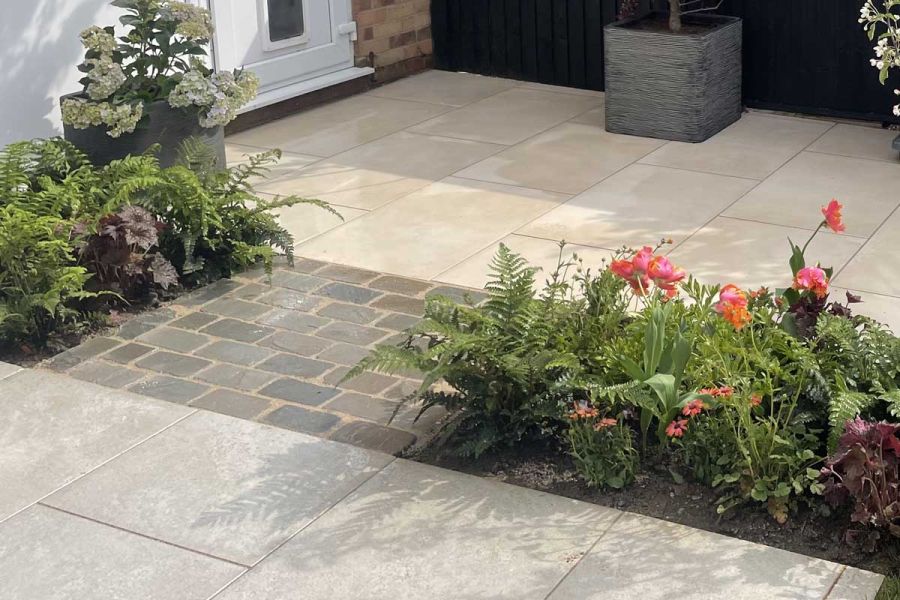 Astor Grey Porcelain Paving used in ITV's Love Your Garden. Porcelain pavers used either side of dark clay pavers with surrounding foliage.