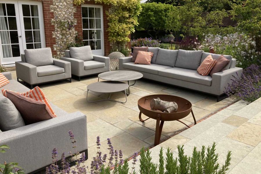 Modern lounge set sits on Antique Yellow tumbled limestone paving. Design by Bo Cook, built by Simon Scott Landscaping.