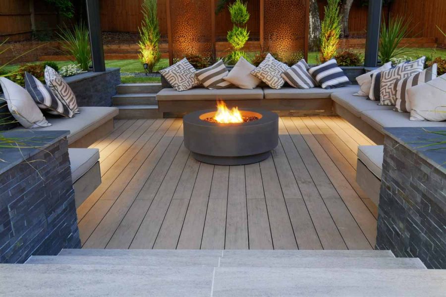 Brazilian Black Slate pencil-round coping stones cap walls around sunken seating area with cushioned cantilevered bench seating.