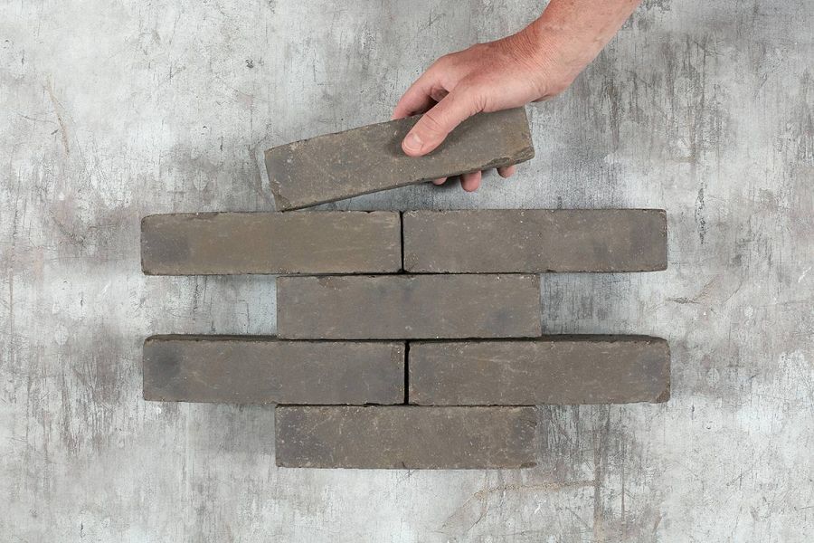 Hand places single Carbona Clay Paver into formation of 6 other bricks arranged in rows of 1 and 2. Free UK delivery available.