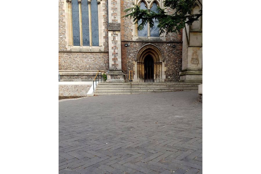 View of St. Albans Cathedral shows charcoal grey brick pavers running up to the front steps. By J & L Gibbons.