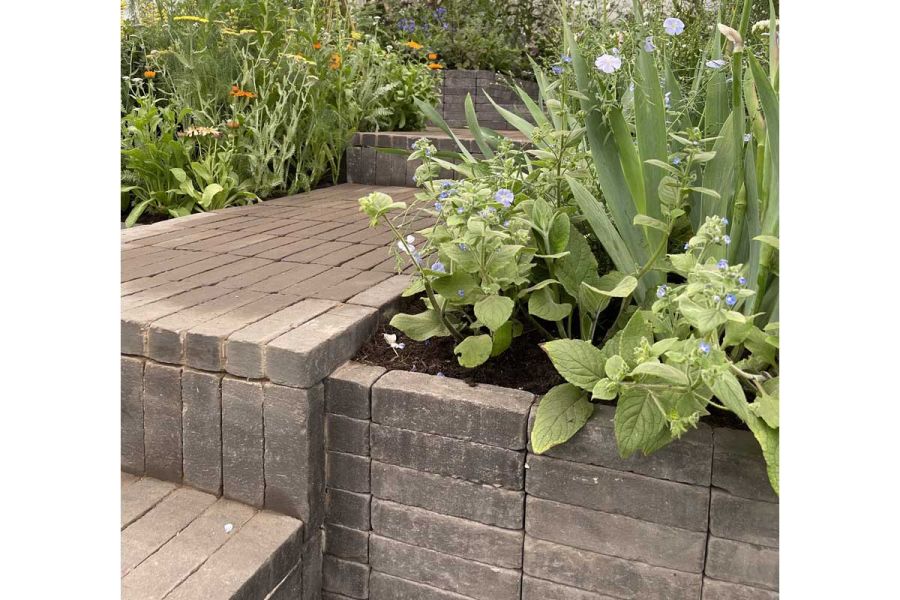 Path and steps of Charcoal Grey Brick Pavers, with risers of upright clay bricks, and retaining walls of beds built stack bond.