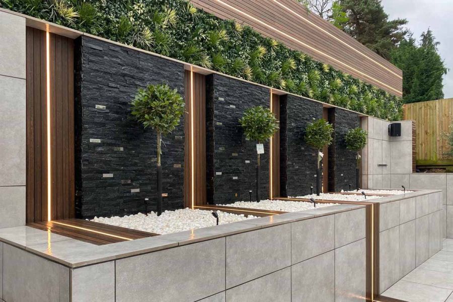 Water feature area with Chestnut Composite Battens and led-light inserts, natural stone cladding and artificial green walls.