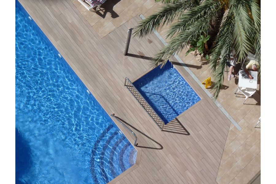 Aerial view of swimming pool and adjacent paddling pool set into large expanse of Cinnamon DesignBoard composite decking.