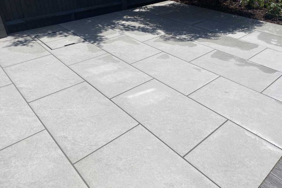 Close-up of Astor Grey Porcelain Paving in bond pattern, showing the natural surface texture. Installed by Coastal Gardens.