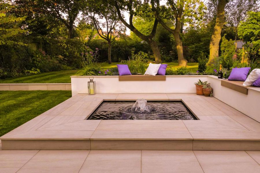 Square pond with water feature set in Faro porcelain paving. Built by Brockstone Landscape Construction. Design by Dee Stewart..