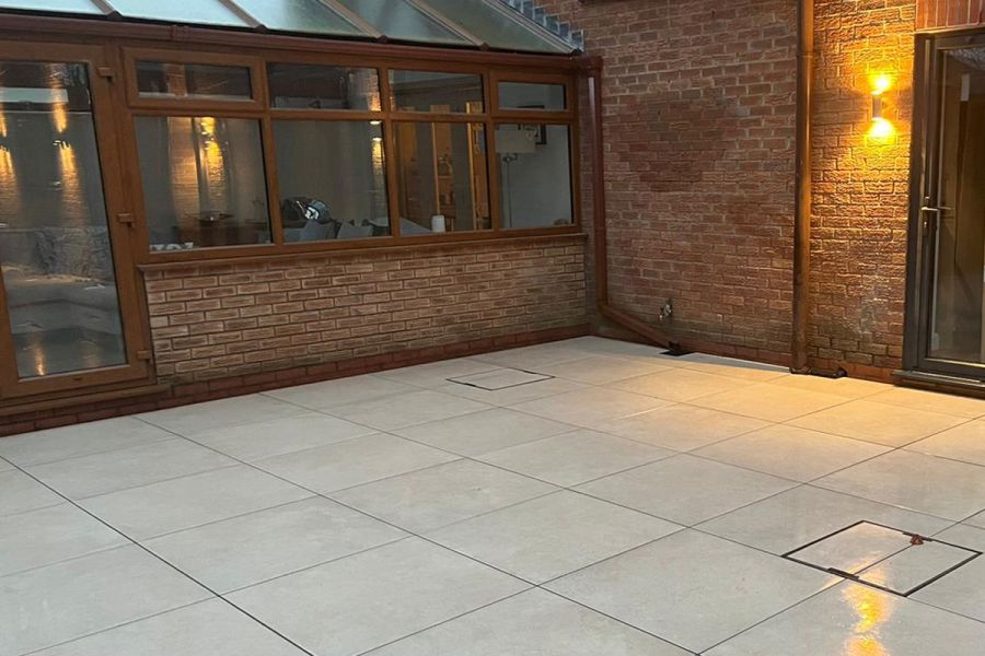 Functional patio area coming off the back of a house using Corda 800x800 porcelain slabs laid in a stack bond pattern.
