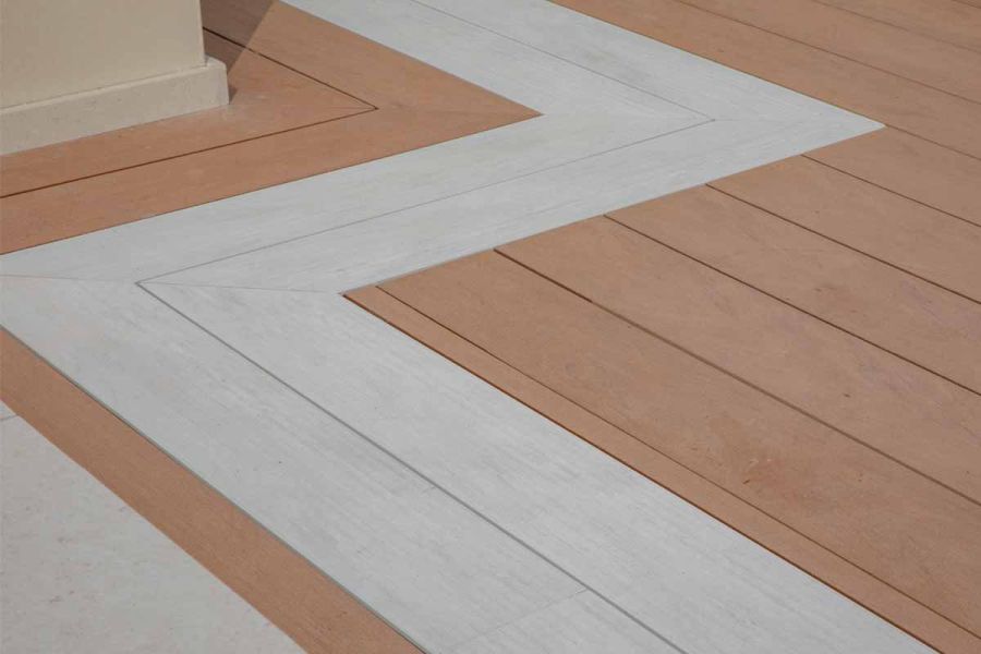 Close-up of Mocha composite decking boards with Polar Designboard decking forming zigzag with mitred corners at corners.