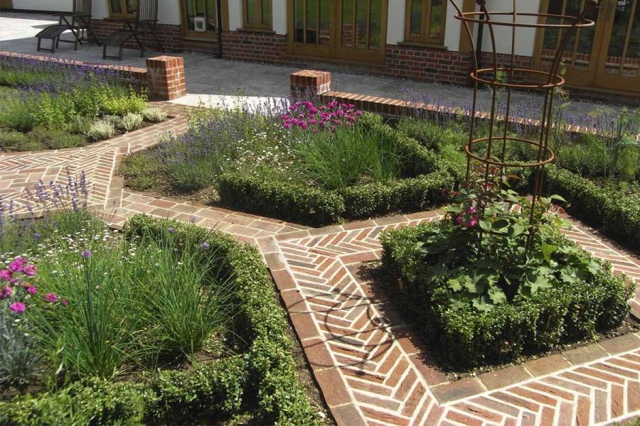 Traditional garden of herb and vegetable beds with box hedging between paths of Dorset Antique clay pavers laid flat and edge on.