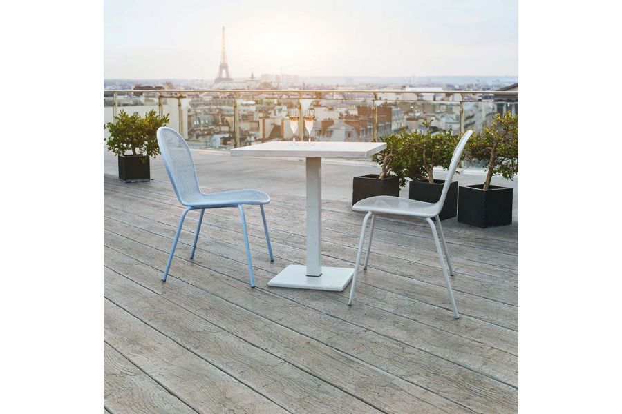 2 chairs and table on roof top in Paris with view of Eiffel Tower, completed decked in Driftwood grey Millboard.