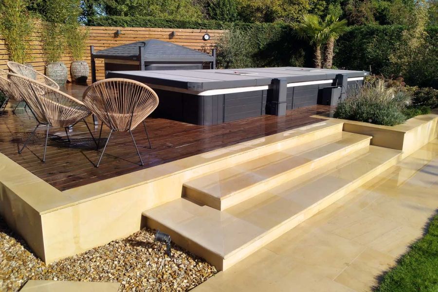 2 steps rise to patio with covered pool, faced and edged with Dune sawn sandstone coping. By Duncan Ross Garden Design.