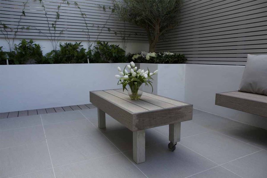 Urban Grey exterior porcelain pavers have pale jointing to match white-rendered raised beds with climbers on batten fence.